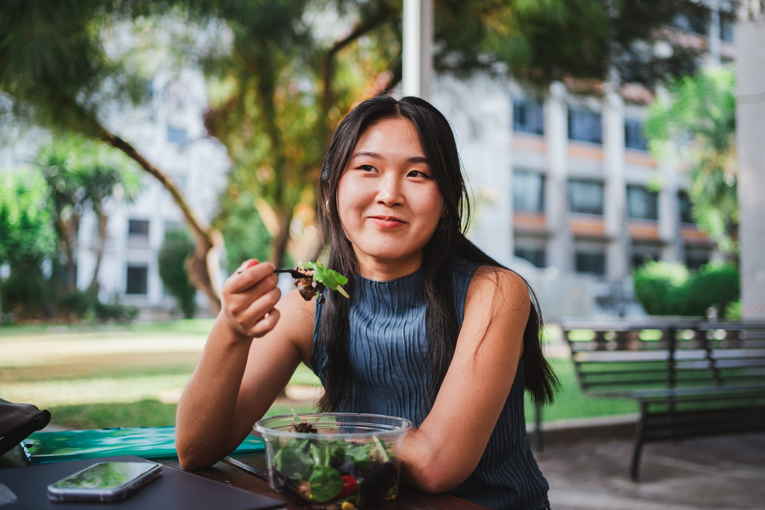 College student eating a salad on campus